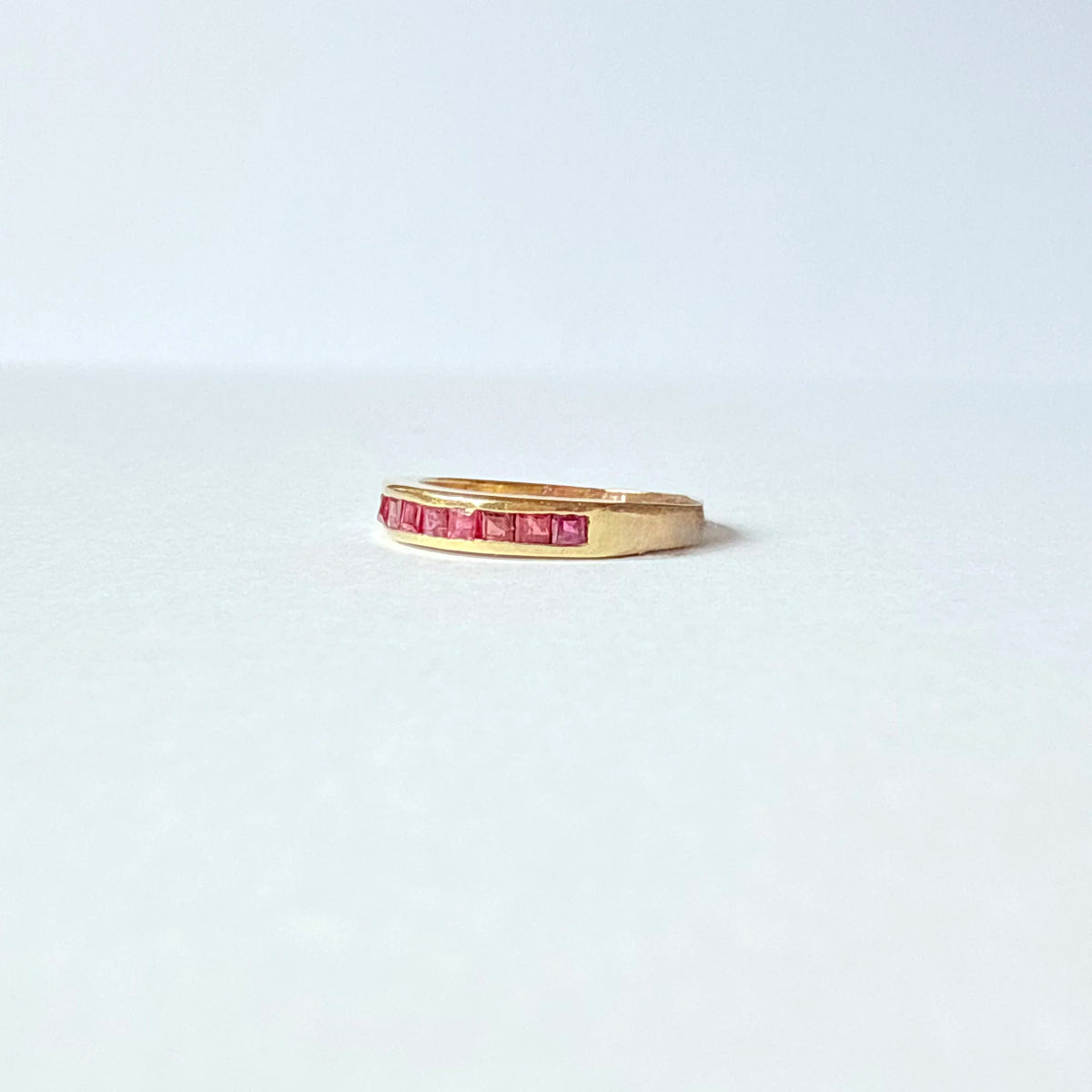 demi-alliance vintage en or jaune 18 carats et rubis en serti clos.