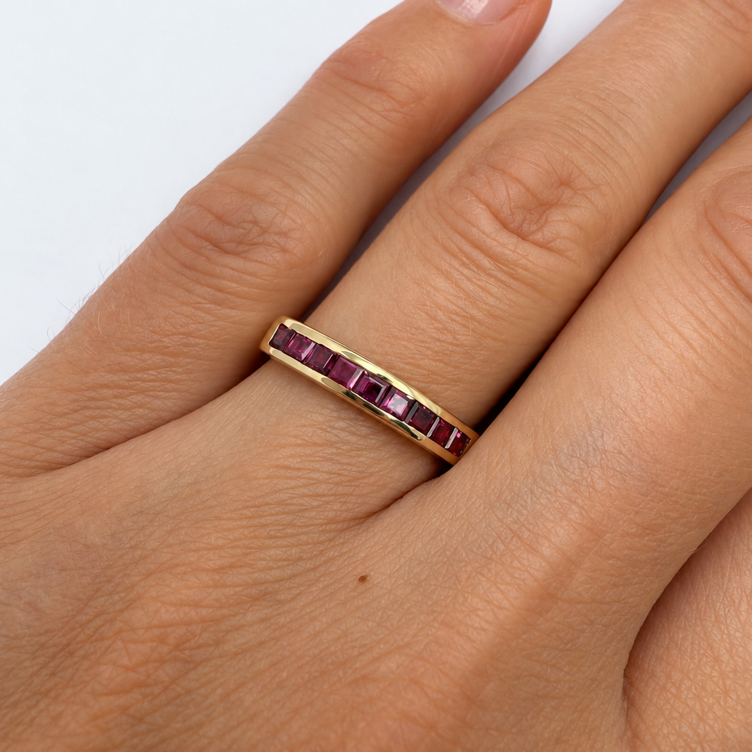 bague vintage demi-alliance en or jaune 18 carats ornée de rubis calibrés.