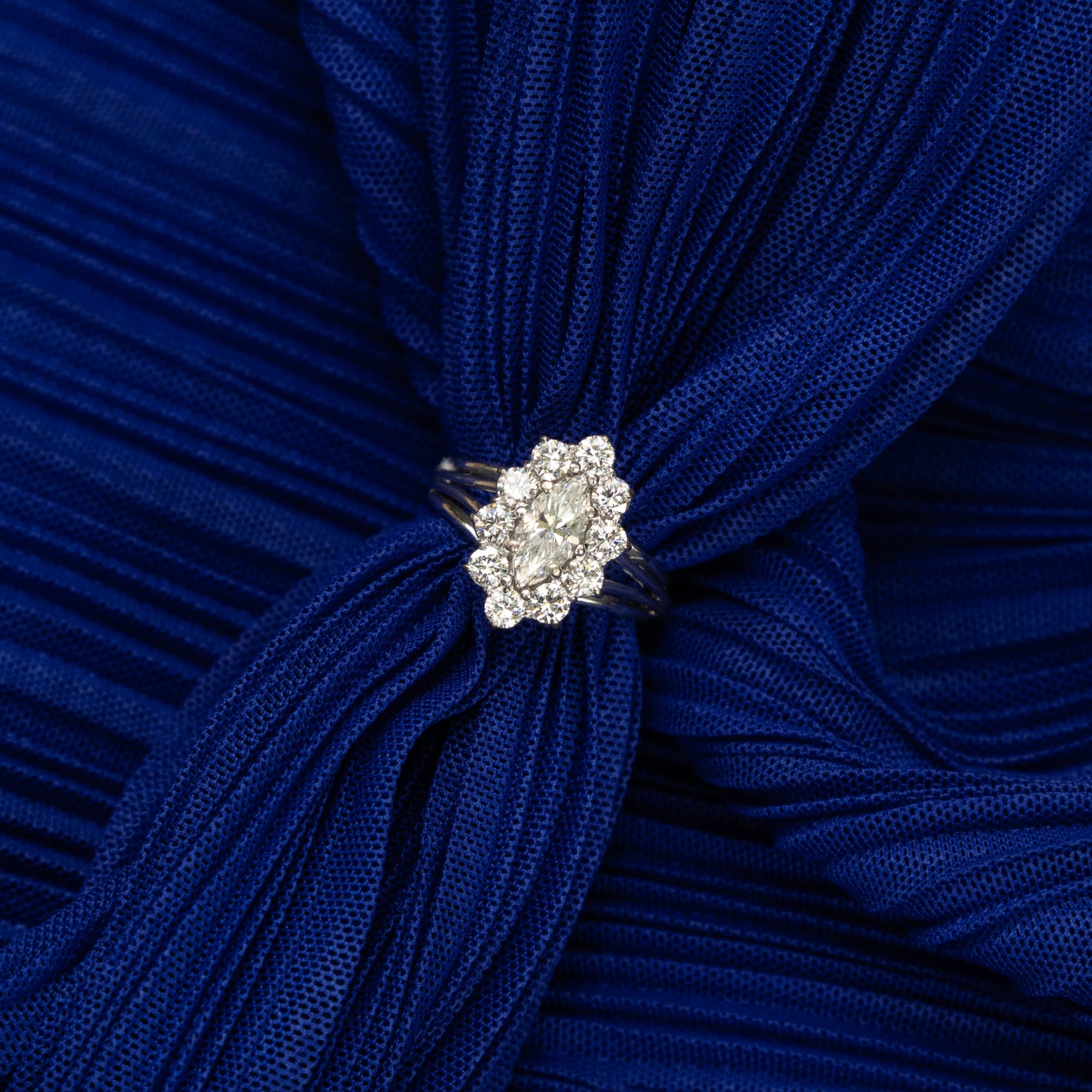 Bague marquise en or blanc 18 carats ornée d’un diamant taille navette de 0,4 carat entouré de dix diamants modernes en serti griffe, bijou raffiné et intemporel.