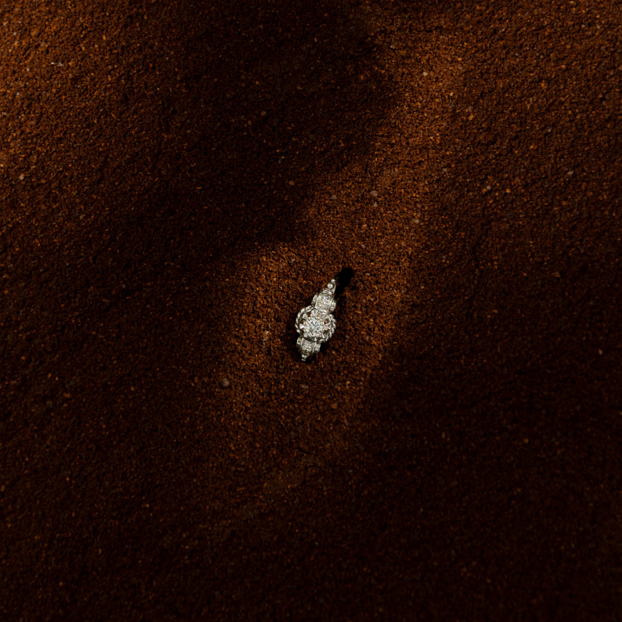 Bague ancienne en or blanc 18 carats ornée d’un diamant taille brillant d’environ 0,1 carat, monture à volutes et torsades inspirée de l’Art Déco, bijou élégant des années 1950.