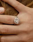 Bague ancienne en or 18k et diamants formant un trèfle à quatre feuilles, portée sur un doigt, idéal pour des fiancailles ou un cadeau d'exception.