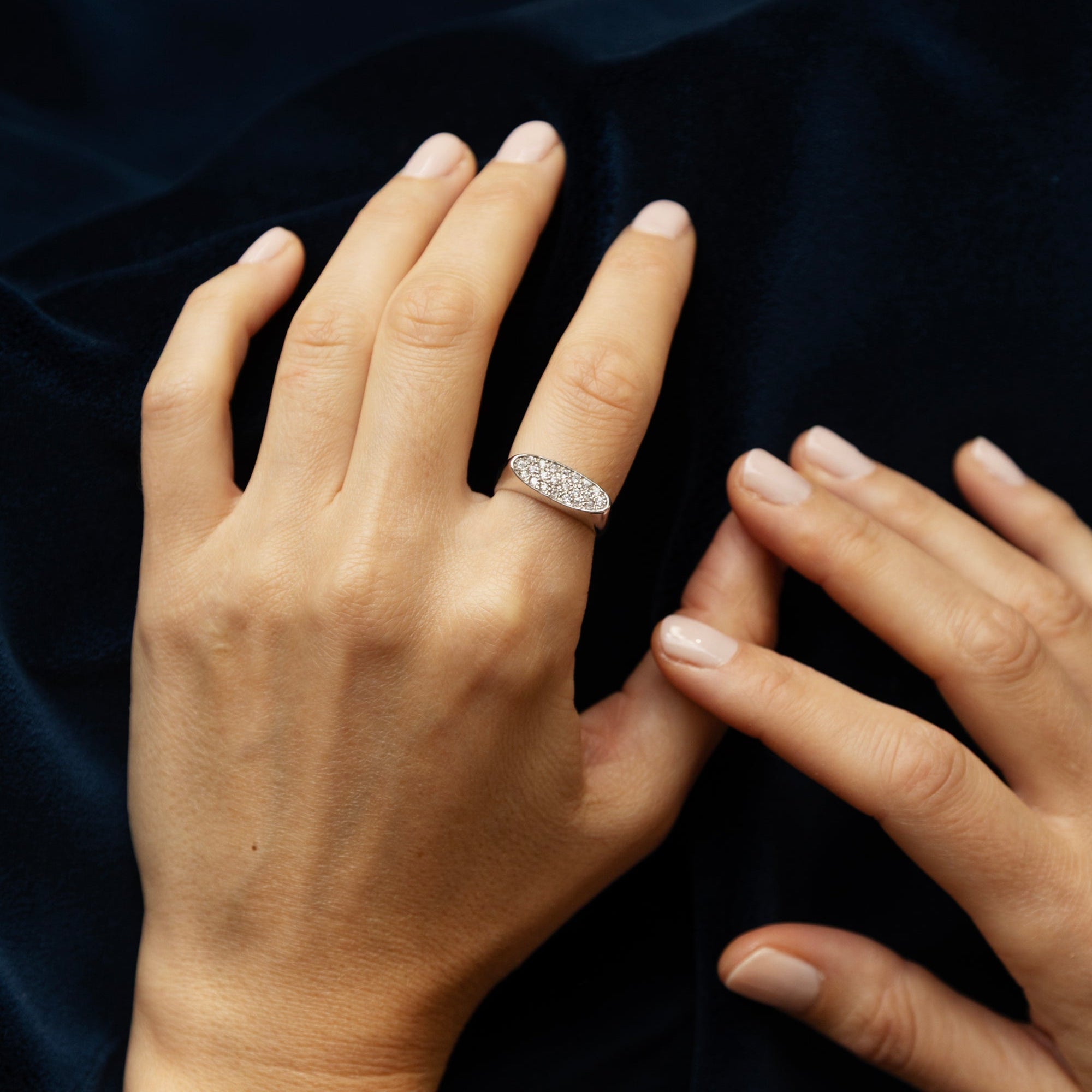 Bague diamant en or gris 18 carats, plateau ovale pavé de diamants taille brillant, portée au doigt
