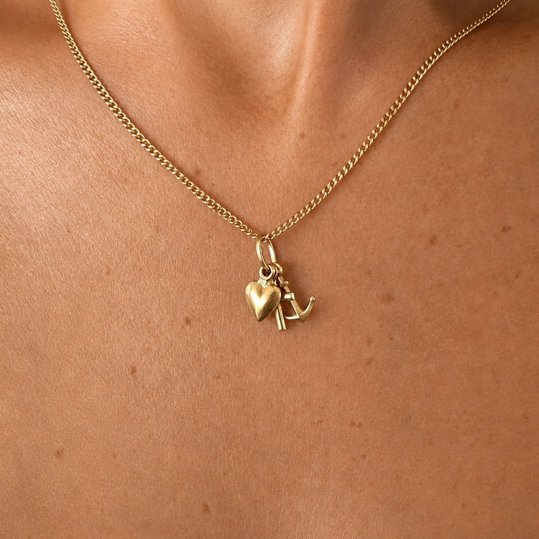 Pendentif symbolique en or jaune composé d'une croix, d'une ancre et d'un cœur