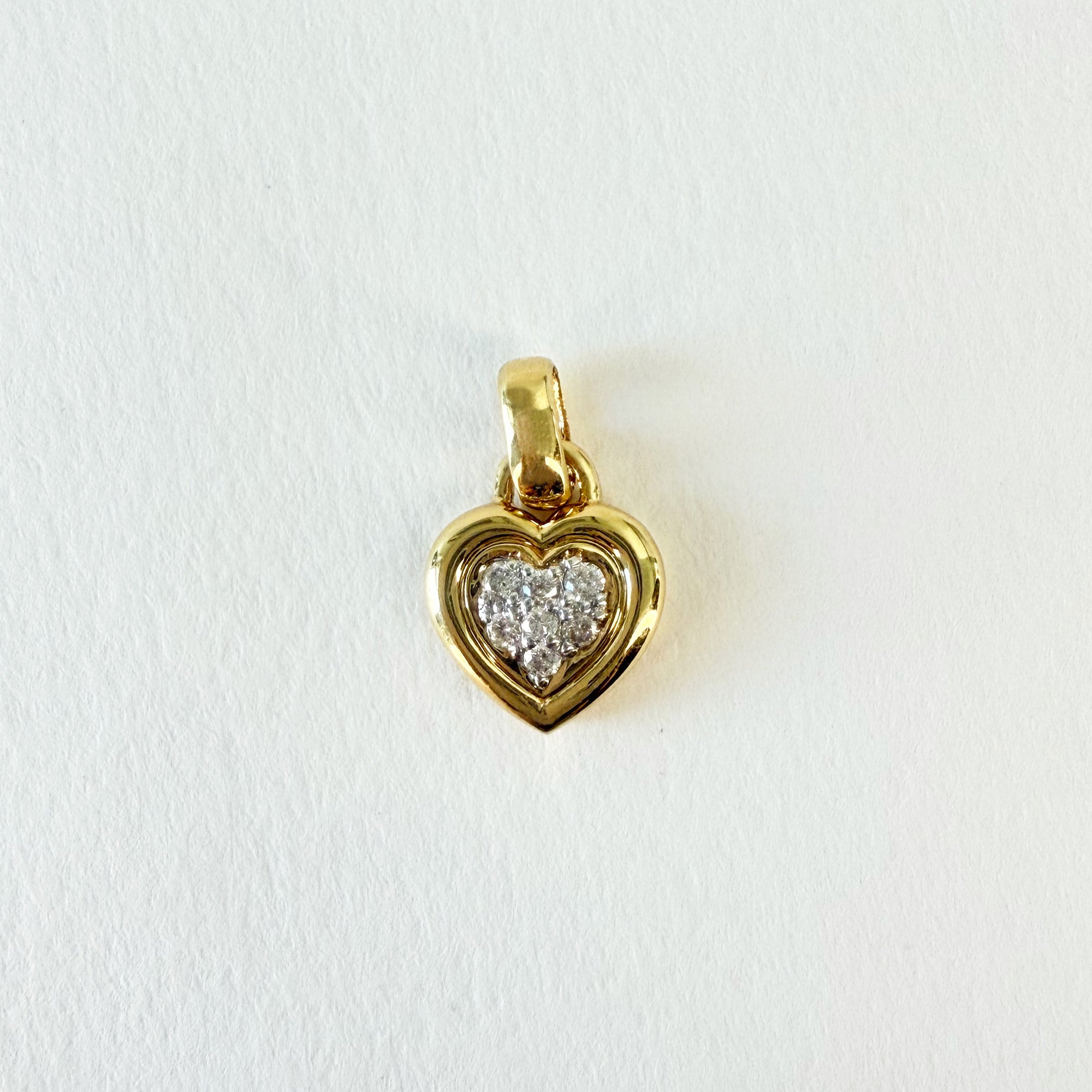 Pendentif en forme de cœur en or jaune 18 carats pavé de sept diamants taille brillant, bijou raffiné et lumineux symbole d’amour et d’élégance.
