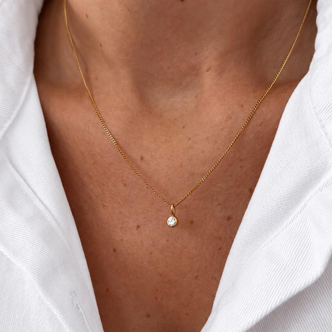 Collier en or jaune 18 carat ornée d'un pendentif diamant naturel de 0.1 carat, montré autour du cou