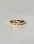 Bague solitaire en or jaune 18 carats sertie d’un diamant en serti clos d’environ 0,07 carat, bijou raffiné symbole d’amour éternel et d’engagement.