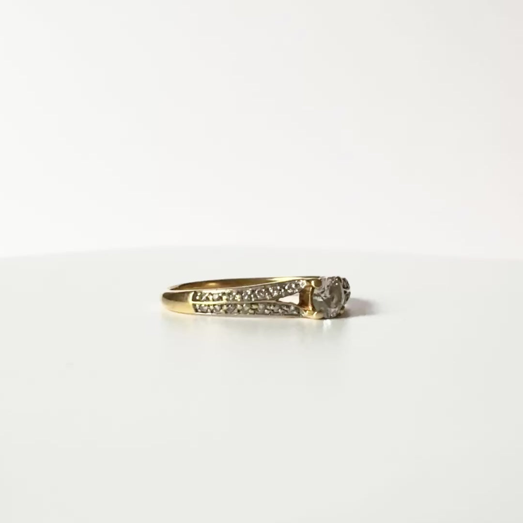 vidéo montrant une bague en or jaune 18 carats, pavage de diamants et diamant central de 0,2 carat qui tourne. 