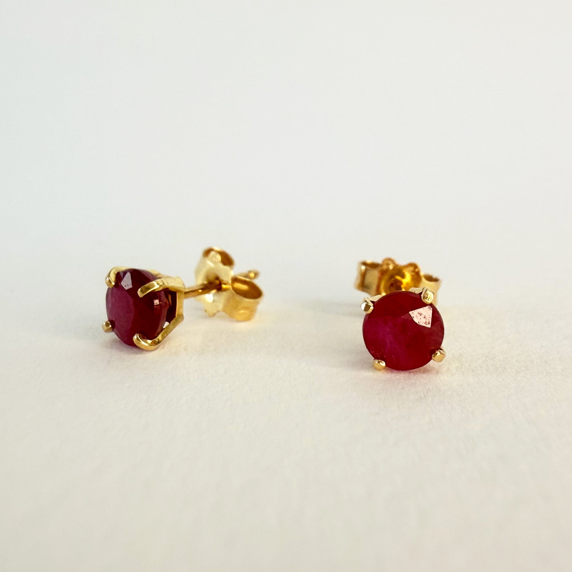 Paire de puces d’oreilles en or jaune 18 carats ornées de rubis ronds en serti griffe, bijoux élégants et colorés à porter au quotidien.