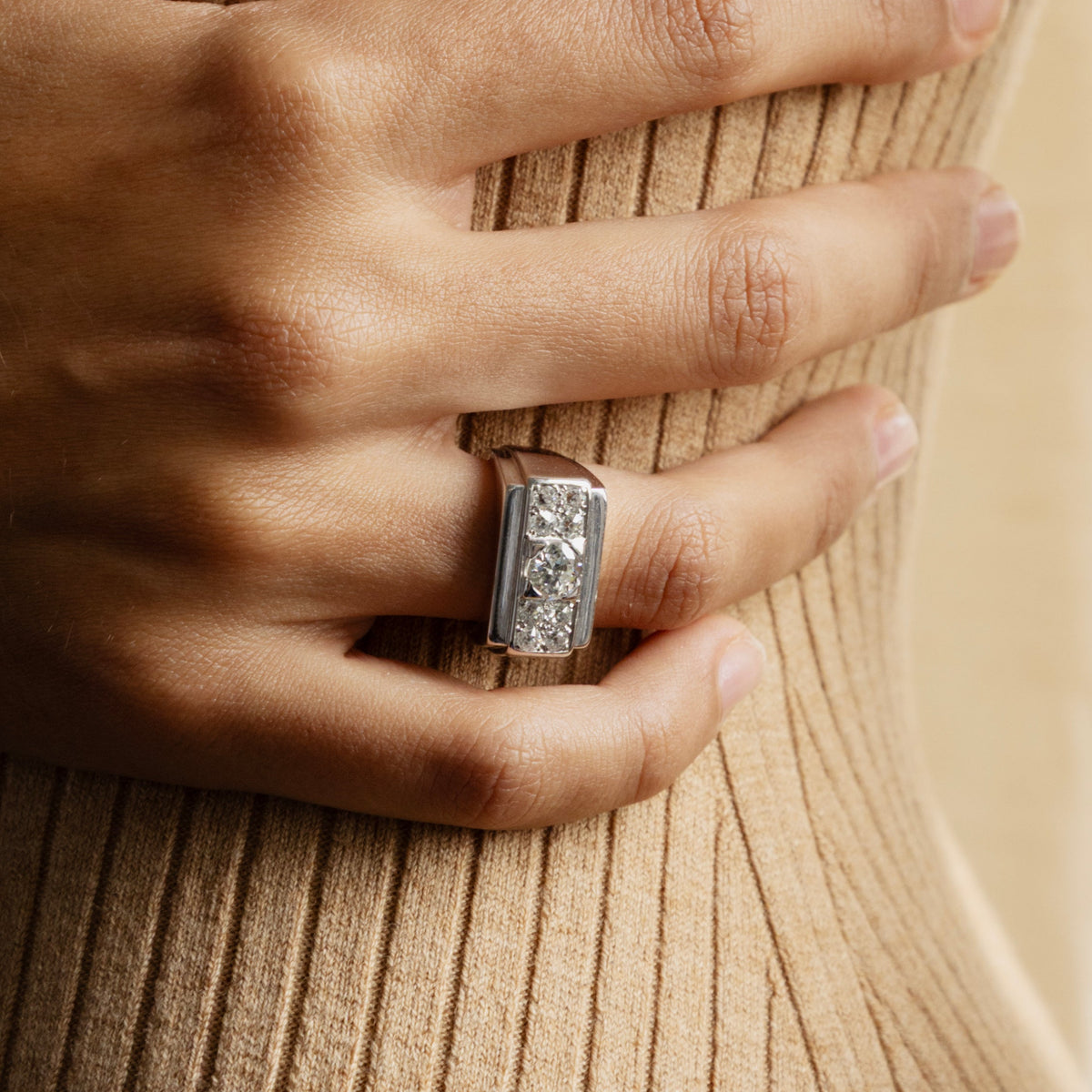 Bague Tank Art Déco en or gris 18 carats avec diamant central et entourage de 8 diamants taille brillant, bague de fiançailles vintage années 1950, portée au doigt.