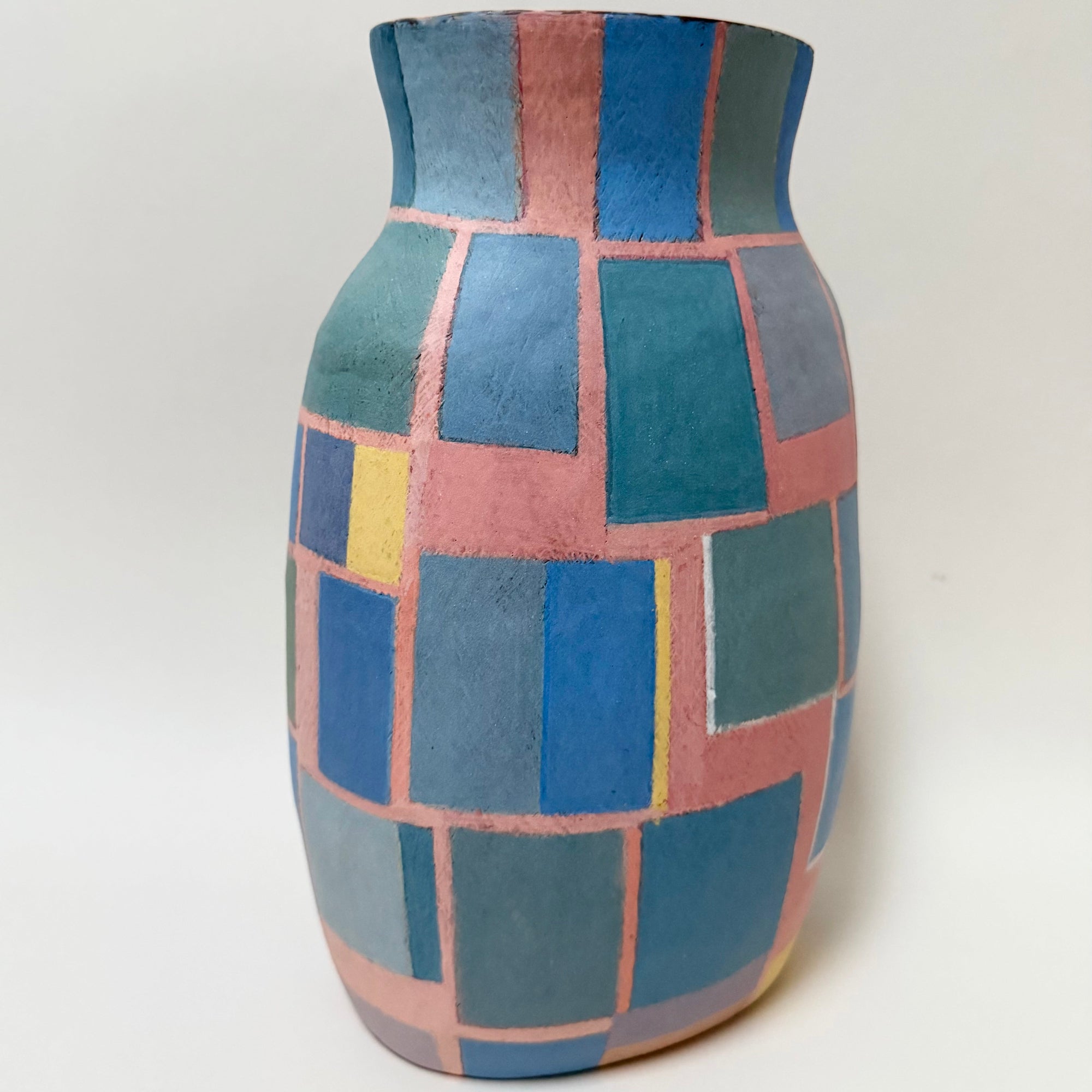 Par son équilibre entre lignes géométriques et nuances délicates, ce vase en céramique offre une lecture à la fois graphique et apaisée. Les couleurs mates, subtilement posées à la main, dialoguent avec l’émail brillant de l’intérieur, conférant à la pièce une profondeur visuelle singulière. Œuvre unique de la création allemande des années 1970, elle s’impose comme un objet de caractère, pensé autant comme sculpture que comme contenant.