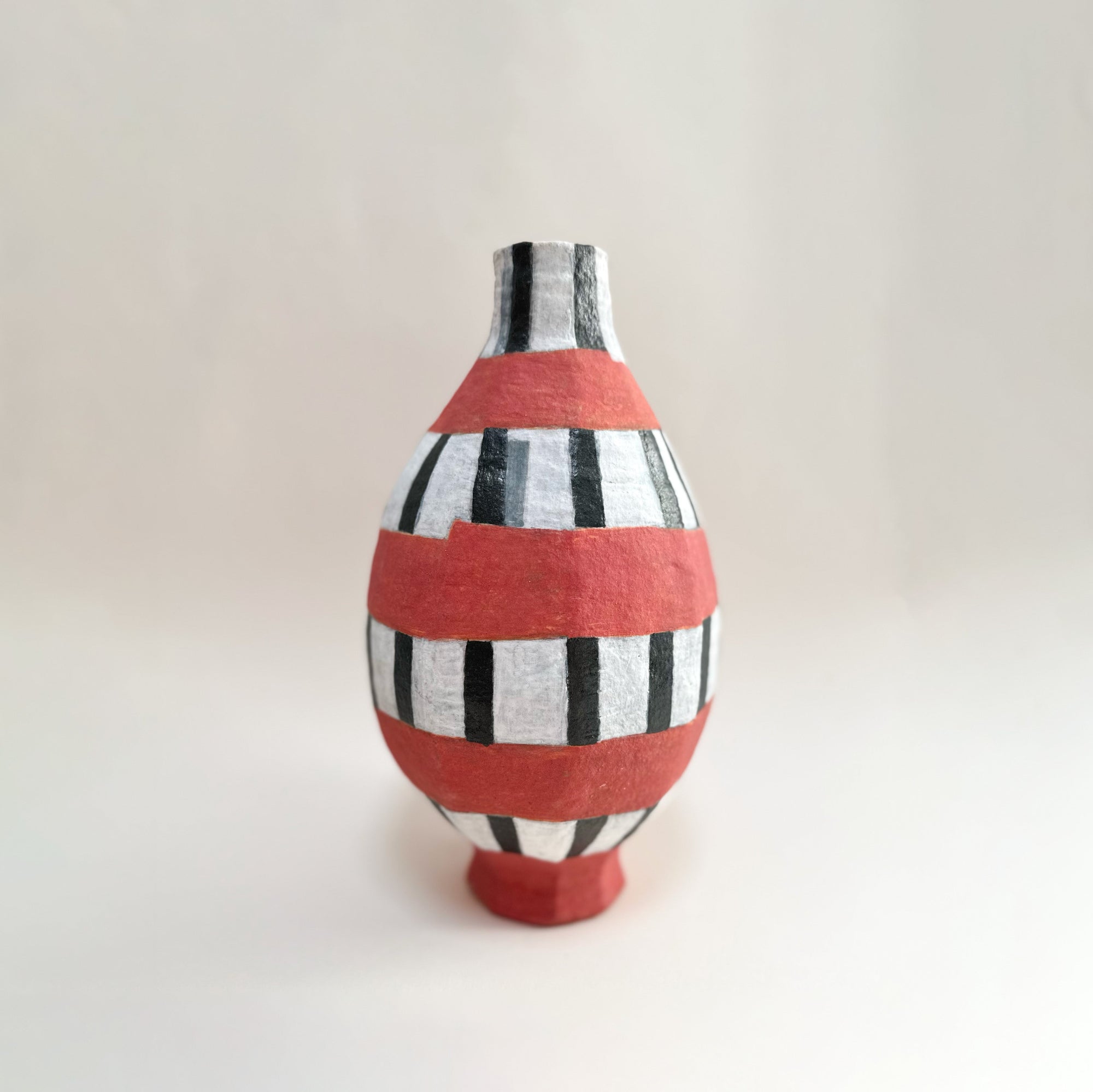 Détail vase céramique émaillée motifs géométriques rouges noirs blancs finition mate artisanale